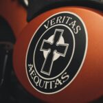 Artistic close-up of a Veritas Aequitas emblem on a motorcycle, featuring a cross design.
